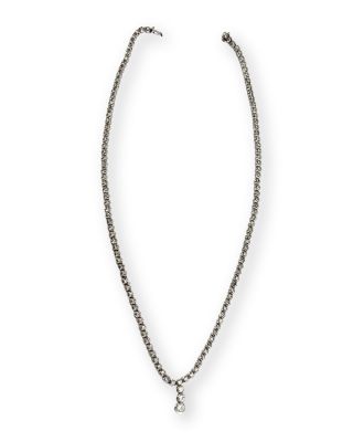 un collier en argent avec un pendentif en diamant au bout d'une chaîne