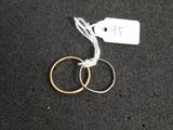 two rings on a black surface with a price tag