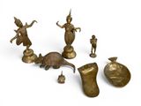 brass figurines and other items are displayed on a white surface