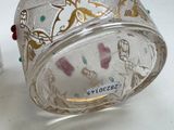 a glass container with a design on it sitting on a table