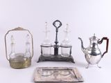 Plusieurs objets en argent et en verre sont exposés sur une surface blanche