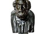 statue représentant le buste d'un homme barbu, posée sur une table en marbre