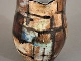 a brown and blue vase sitting on a table