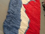 a large red, white and blue sleeping bag on the floor
