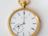 a gold pocket watch with roman numerals on the face