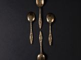 three spoons and a spoon rest on a black surface