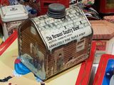 a small tin box with a picture of a house on it