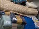 many pillows and blankets stacked on top of each other