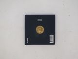 a black book with a gold coin on top of it