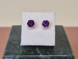 une paire de boucles d'oreilles en améthorate violet sur une carte blanche