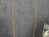 un collier en or et un sac rempli de bijoux posés sur une table