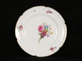 a white plate with flowers on it on a black background