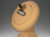a sculpture of a ring sitting on top of a wooden stand