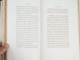 a person holding a book open on a table