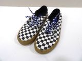 black and white checkered sneakers with blue laces on a white surface