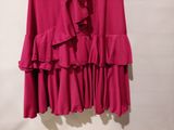 a close up of a pink dress hanging on a hanger