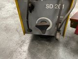 a close up of a machine with a hose attached to it in a warehouse