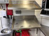 a stainless steel sink in the corner of a kitchen
