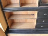 a black and wood cabinet with drawers and shelves