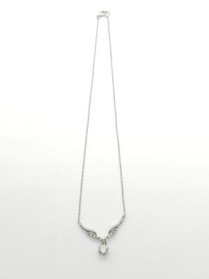 un gros plan d'un collier sur une surface blanche avec un fond blanc