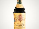 an old bottle of wine sitting on top of a table
