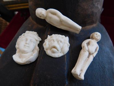 une statue représentant un homme et trois figurines posées sur une table