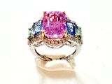 une bague sertie de diamants roses et bleus sur un fond blanc