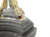 a bronze statue of a dog on a pedestal on a white background