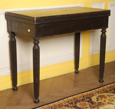 a black table with a brown top in a yellow room