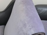a purple couch with a black leather arm rest