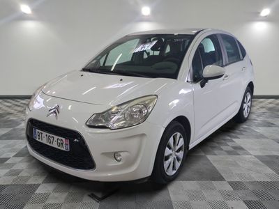 la petite voiture blanche est garée sur un carrelage à carreaux