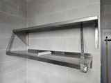 une étagère métallique fixée au mur de la salle de bains