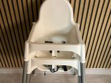 a baby high chair that is in the corner of the room