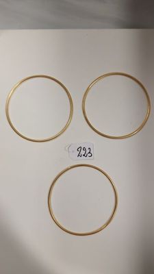 trois bagues en or avec une étiquette de prix sur fond blanc