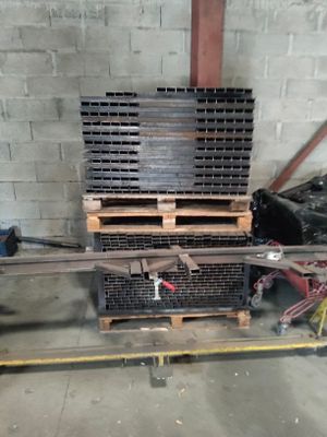 un tas de barres d'acier posées sur une palette dans un entrepôt
