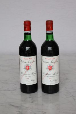 two bottles of red wine sitting on top of a marble counter top