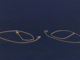 une paire de boucles d'oreilles créoles en or sur fond bleu