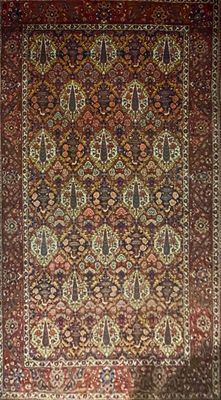 un tapis persan ancien aux motifs rouges et dorés