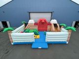 un toboggan aquatique gonflable orné d'un bateau et de palmiers