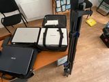 un bureau sur lequel se trouvent un ordinateur portable, un appareil photo, un écran et un trépied