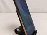 a close up of a cell phone on a stand on a white surface