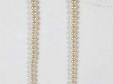 collier avec des perles blanches et un fermoir en argent sur fond blanc