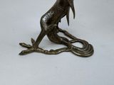a statue of a bird sitting on a branch