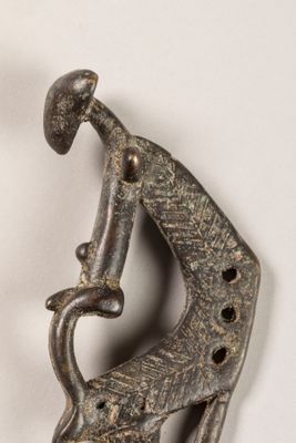 une sculpture métallique représentant une girafe portant un oiseau sur son dos