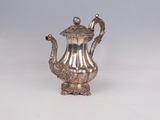 a silver tea pot on a white table