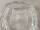 a glass ashtray with a cat in the middle of it