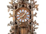 a wooden clock with a bird on top of it