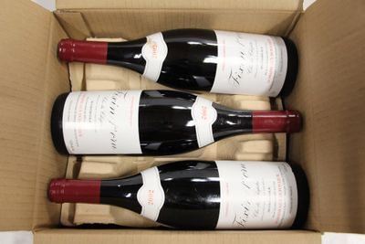 three bottles of wine in a cardboard box on a table