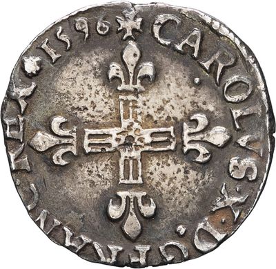 a silver coin with an image of a cross on it