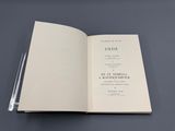 un livre ouvert posé sur une table, à côté d'un stylo